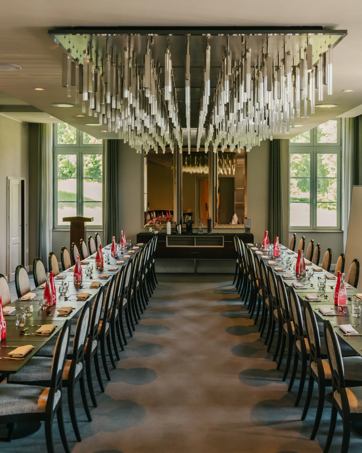 Speisesaal mit gedeckten Tischen und von der Decke hängenden Kandelabern