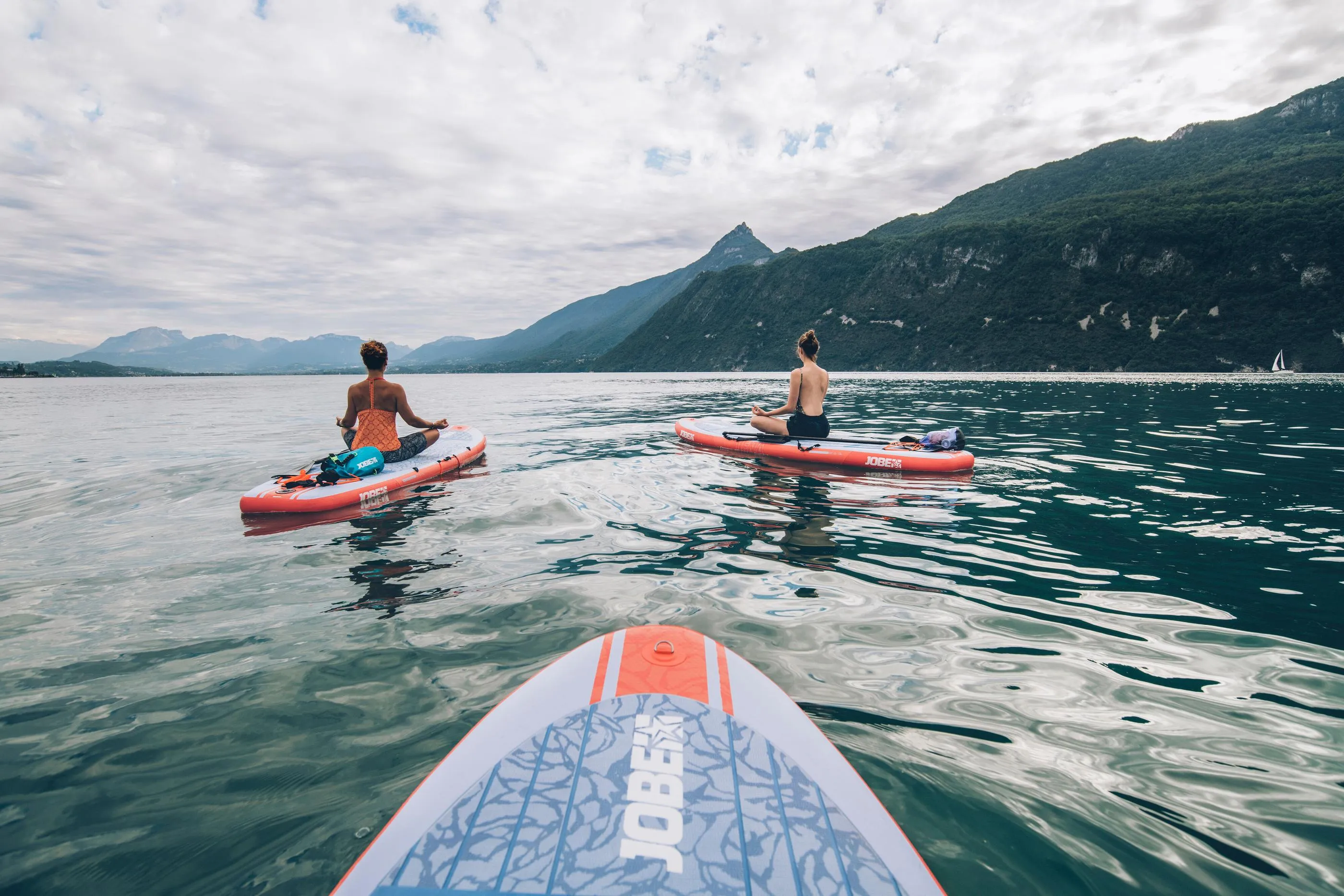 Deux personnes font du paddle sur un lac encadré de montagnes