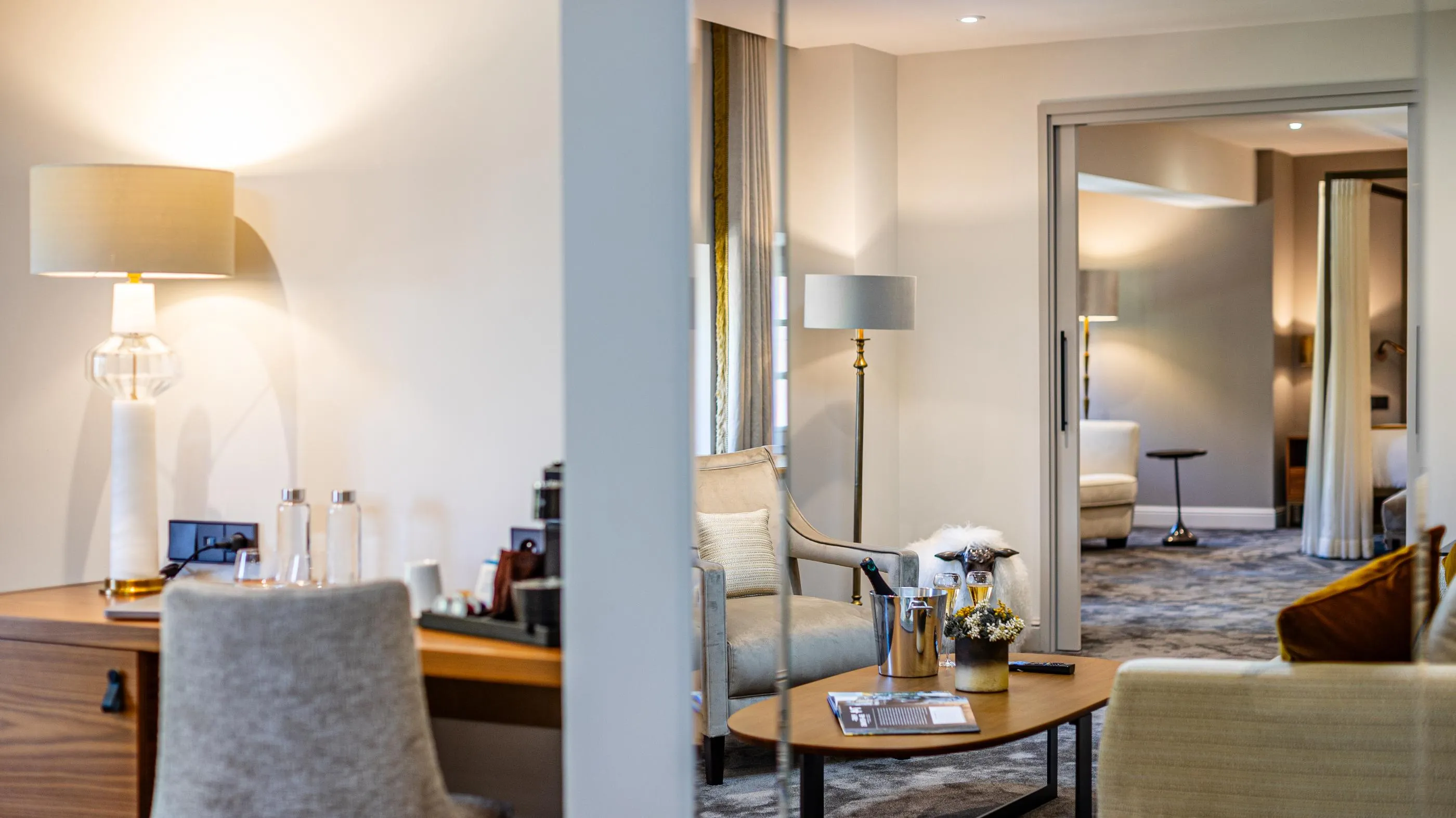 Hotel lounge with armchairs, coffee table, lamps and champagne bottles